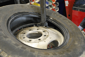 Installing the top tire bead over the rim